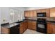 Kitchen with dark wood cabinets, black appliances and a tile floor at 4554 W Whitten Ct, Chandler, AZ 85226