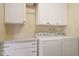 Laundry room with washer, dryer, and white cabinets at 9917 W Raintree Dr, Sun City, AZ 85351