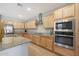 Modern kitchen with light wood cabinets, granite counters, and stainless steel appliances at 15072 W Mckinley St, Goodyear, AZ 85338