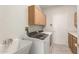 Well-lit laundry room with cabinets and utility sink at 16319 W Mission Cove Ln, Surprise, AZ 85374