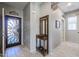 Entryway with tile flooring, coat rack, and access to office and bath at 17915 W Silver Fox Way, Goodyear, AZ 85338