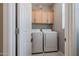 Laundry room with washer, dryer, and overhead cabinets at 17915 W Silver Fox Way, Goodyear, AZ 85338