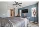 Main bedroom with large bed and wall-mounted TV at 17915 W Silver Fox Way, Goodyear, AZ 85338