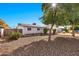 Ranch style home with a gravel front yard, mature trees, and a white exterior at 18025 N Villa Rita Dr, Phoenix, AZ 85032