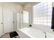 Bathroom with soaking tub, shower, and a large window at 18174 W Wind Song Ave, Goodyear, AZ 85338