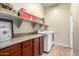 Bright laundry room with washer, dryer, and ample storage at 18174 W Wind Song Ave, Goodyear, AZ 85338