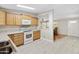 Open kitchen with light wood cabinets, view into dining area, and laminate flooring at 3330 E Main St # 111, Mesa, AZ 85213