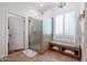 Bathroom with glass shower, built-in bench, and wood-toned cabinets at 13425 W Los Bancos Dr, Sun City West, AZ 85375