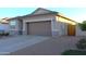 Tan house with a brown garage door and desert landscaping at 1589 E Squire Dr, Casa Grande, AZ 85122