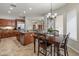 Kitchen and dining area with island, dining table, and wood cabinetry at 30680 N 126Th Dr, Peoria, AZ 85383