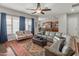 Open concept living room with leather sectional sofa, ceiling fan, and view of kitchen at 30680 N 126Th Dr, Peoria, AZ 85383