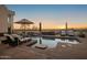 Peaceful pool area at sunset with lounge chairs and fire pit at 35037 N El Sendero Rd, Carefree, AZ 85377