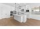 Modern white kitchen with stainless steel appliances and an island at 37730 W Padilla St, Maricopa, AZ 85138