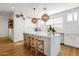 Modern kitchen with white cabinets, a large island, and wicker pendant lights at 4141 E Pony Ln, Gilbert, AZ 85295