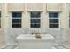 Elegant bathroom with marble tile, soaking tub, and double vanity at 10255 E Diamond Rim Dr, Scottsdale, AZ 85255