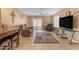 Living room with tiled floors and a large TV at 14834 W Calavar Rd, Surprise, AZ 85379