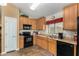 Bright kitchen with wood cabinets, black appliances, and tile flooring at 6906 E Sisso Pl, Florence, AZ 85132