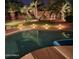 Inviting backyard pool and spa with landscape lighting at night at 18228 N San Salvador Ct, Surprise, AZ 85374