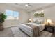 Spacious bedroom with a large bed, nightstands, and a window at 12618 W Columbine Dr, El Mirage, AZ 85335