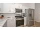 Modern kitchen with white cabinets, stainless steel appliances, and marble countertops at 13733 W Redfield Rd, Surprise, AZ 85379