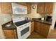 Kitchen with white appliances and ample wood cabinetry at 1398 S Cheyenne Dr, Apache Junction, AZ 85119