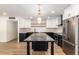 Modern kitchen with black and white cabinetry, marble island, and new appliances at 2202 W Berridge Ln, Phoenix, AZ 85015