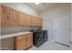 Laundry room with wood cabinets, countertop, and washer and dryer at 31315 N 155Th St, Scottsdale, AZ 85262