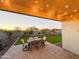 Evening view of covered patio with string lights and seating area at 37054 N Addison Ln, San Tan Valley, AZ 85140