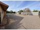 Spacious backyard with gravel, desert landscaping, and a covered patio at 5702 E Casper Rd, Mesa, AZ 85205