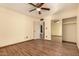 Bedroom with wood flooring, mirrored closet, and access to bathroom at 8534 N 106Th Ln, Peoria, AZ 85345