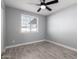 Simple bedroom with grey walls, wood-look tile floors, and a window with blinds at 8840 W Desert Cove Ave, Peoria, AZ 85345