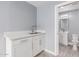 Laundry room with white cabinets, sink, and access to a full bath at 8840 W Desert Cove Ave, Peoria, AZ 85345