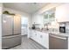 Modern kitchen with white cabinets, granite countertops and stainless steel appliances at 10440 W Kingswood Cir, Sun City, AZ 85351