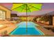 Relaxing pool area with a green umbrella and lounge chairs at 16573 W Valencia Dr, Goodyear, AZ 85338