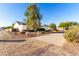 Exterior view of a single-story house with a long driveway and desert landscaping at 19404 W Minnezona Ave, Litchfield Park, AZ 85340