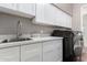 Laundry room with white cabinets, stainless steel sink, and washer/dryer at 19404 W Minnezona Ave, Litchfield Park, AZ 85340