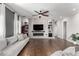 Bright living room with hardwood floors, a fireplace, and a large sectional sofa at 19404 W Minnezona Ave, Litchfield Park, AZ 85340