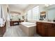 Luxurious bathroom with double sinks, a soaking tub, and block windows at 32722 N 23Rd Ave, Phoenix, AZ 85085