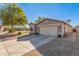 Tan house exterior with a two-car garage and gravel driveway at 42227 W Oakland Dr, Maricopa, AZ 85138