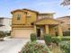 Two-story house with tan exterior, two-car garage, and landscaping at 4319 E Vaughn Ave, Gilbert, AZ 85234