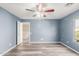 Bedroom with blue walls, wood-look floors, and a ceiling fan at 5240 W St Kateri Dr, Laveen, AZ 85339