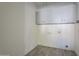 Laundry room with gray cabinets and tile floor at 140 E Dawn Dr, Tempe, AZ 85284