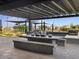 Outdoor kitchen and dining area with a built-in grill and pergola at 16032 W Desert Hollow Dr, Surprise, AZ 85387