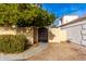 Dark brown wooden gate with a stone wall and lush green bushes at 3348 E Woodland Dr, Phoenix, AZ 85048