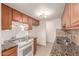 Galley kitchen with wood cabinets, granite counters, and stainless steel sink at 600 S Dobson Rd # 75, Mesa, AZ 85202