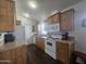 Kitchen with wood cabinets, white appliances, and dark flooring at 8700 E University Dr # 545, Mesa, AZ 85207