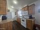 Kitchen with wood cabinets, white appliances, and dark flooring at 8700 E University Dr # 545, Mesa, AZ 85207
