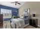 Bright bedroom with a ceiling fan, built-in shelving, and en-suite bathroom at 9512 E Altadena Ave, Scottsdale, AZ 85260