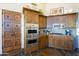 Gourmet kitchen with double ovens, granite counters, and wood cabinets at 15405 E Cavedale Dr, Scottsdale, AZ 85262