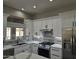 Modern kitchen with white cabinets, quartz countertops, and stainless steel appliances at 15708 W Whitewood Dr, Sun City West, AZ 85375